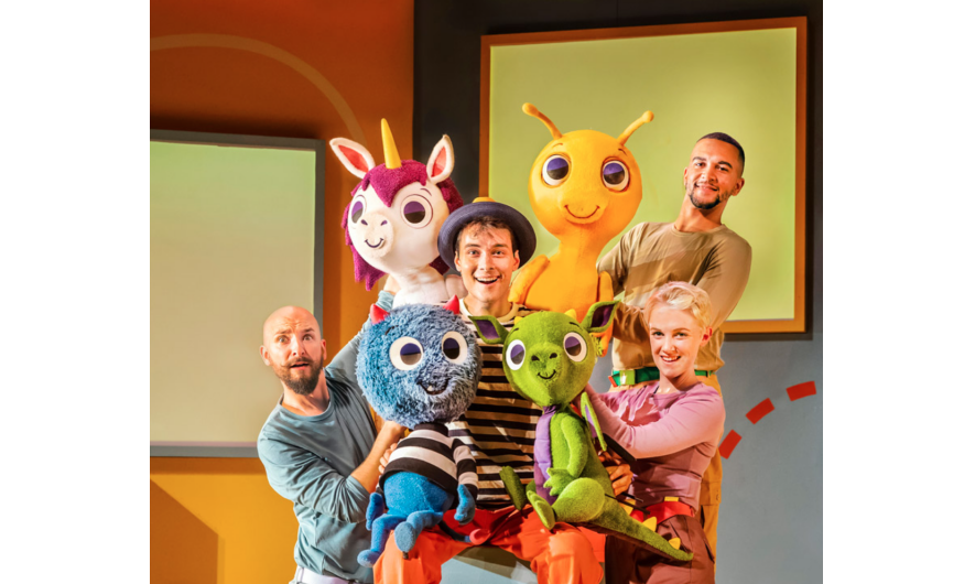The cast of There's A Monster In Your Show on stage with their puppets.