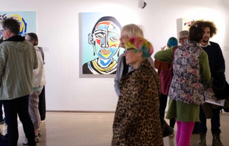 Picture of Tinashe Chipawe's artwork in a busy gallery space.