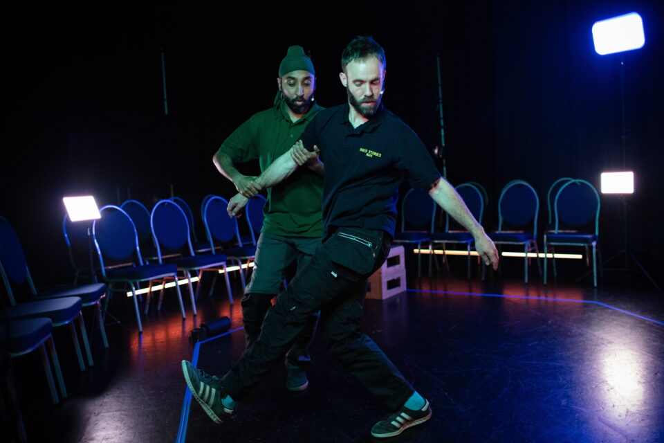 Shows two performers on stage dancing taken from Casson & Friends' Shed Stories rehearsal performance