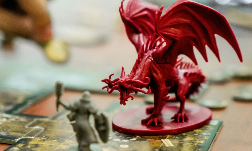 Image depicts a table set up for playing a game of D+D with dice, counters and a dragon figure in the centre.